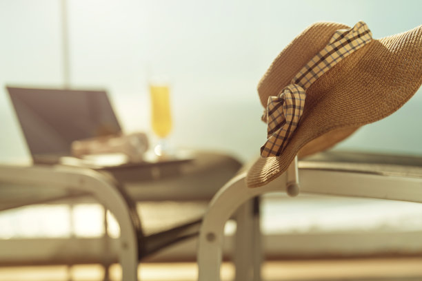 放松旅行自由职业生活方式海景阳台露台笔记本电脑和耳机远程技术设备安排在藤凳上的木地板与阳光晨光度假图片下载