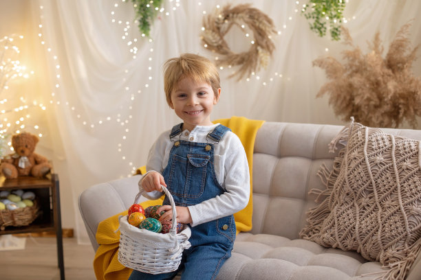 可爱的学前班男孩在工作室，玩，复活节彩蛋和吃巧克力，孩子在复活节假期图片下载