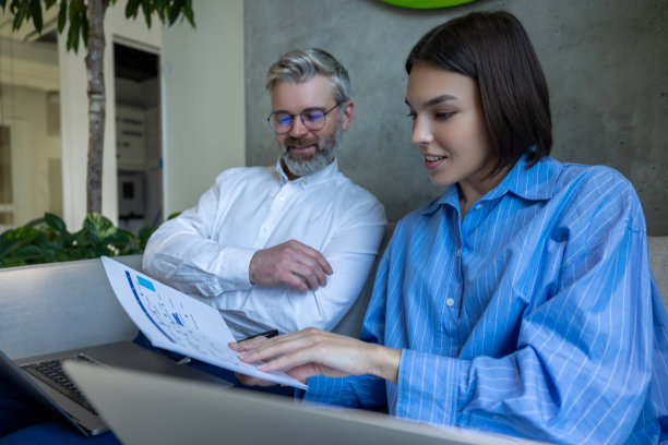 一个男人和一个女人在看报纸的时候看起来很投入图片下载