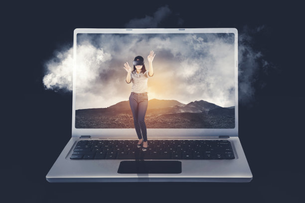 戴着VR眼镜的女人站在一个巨大的笔记本电脑键盘上图片下载