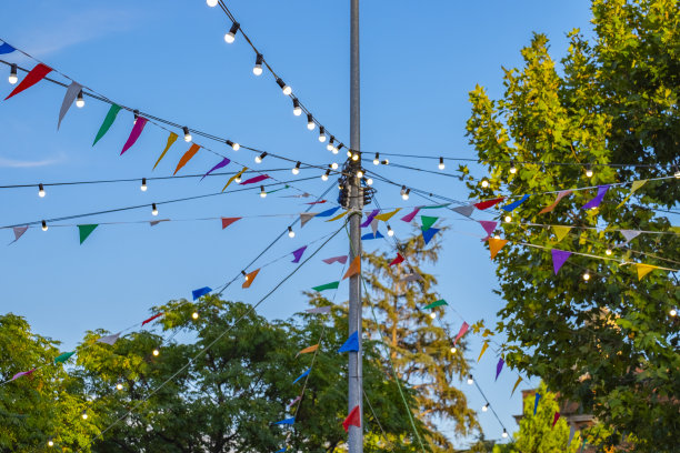 夏日花园日落时，彩旗花环和自制手电筒。庆祝概念生日快乐派对。纸质节日户外装饰。图片下载