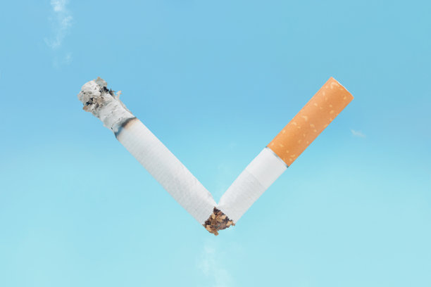 字母V，一个胜利的象征，由一个破碎的香烟在孤立的淡蓝色天空背景。世界无烟日最小创意抽象卡片。戒烟的想法。图片下载