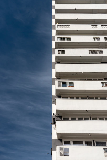 带有白色阳台的现代主义住宅楼。蓝天衬托下的混凝土建筑图片下载