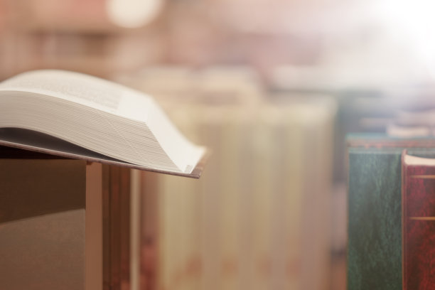 打开古董书的图像与闪烁的背景堆叠的书。图片下载