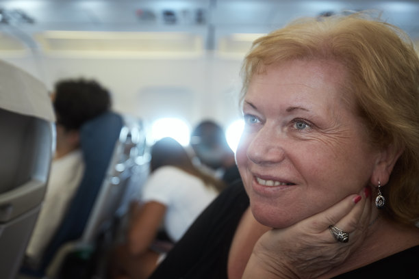 坐飞机旅行时，看起来很梦幻的资深女性图片下载