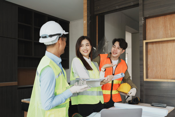 多民族工程师集思广益，对房屋和建筑物的设计、建筑和工程的图纸和平面图进行成本估算图片下载