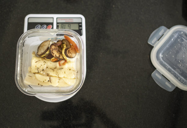 在厨房称上称重的食物容器图片下载