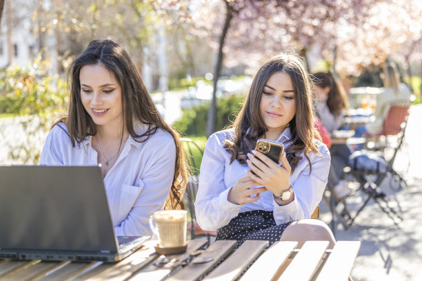 Influencer girl are working and enjoying at the good weather at the sidewalk café图片下载