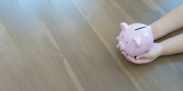 孩子手里拿着存钱罐，存钱的概念图片下载