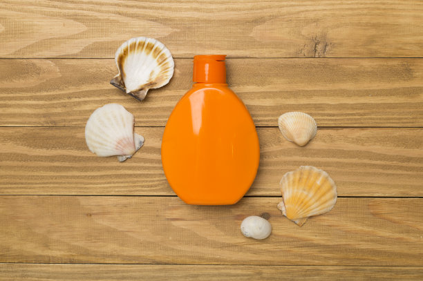 瓶子与防晒霜和贝壳木制背景，俯视图图片下载