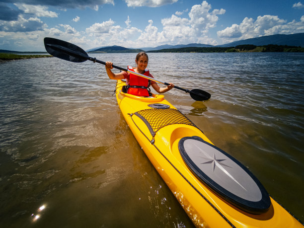 人与自然。女子在山上的湖上划船。图片下载