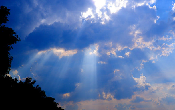 阳光透过云层照射在蓝天上:可以作为背景和戏剧效果图片下载