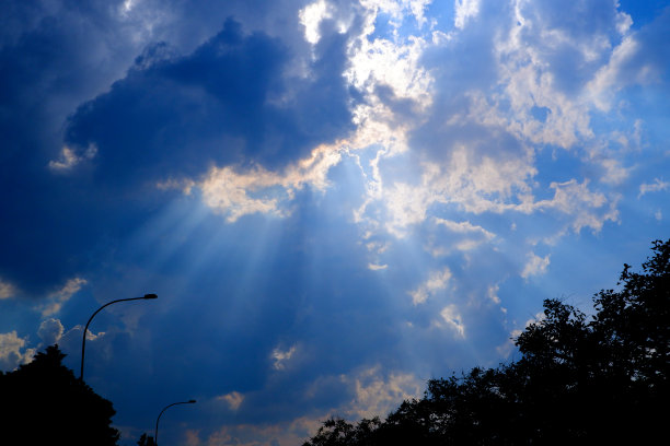 阳光透过云层照射在蓝天上:可以作为背景和戏剧效果图片下载