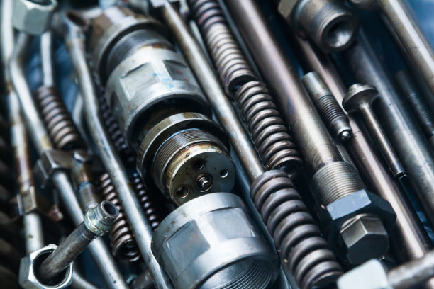 涂有机油的钢制机械部件，特写。钢制喷嘴、弹簧、螺柱、联轴器和管。图片下载