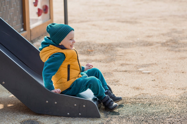 春天里，一个小男孩走在操场上。那孩子骑马下山玩得很开心。儿童和儿童发展。图片下载