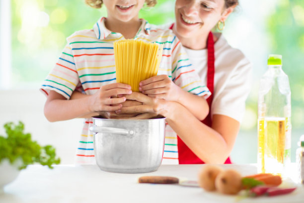 家庭烹饪晚餐妈妈和孩子做意大利面图片下载