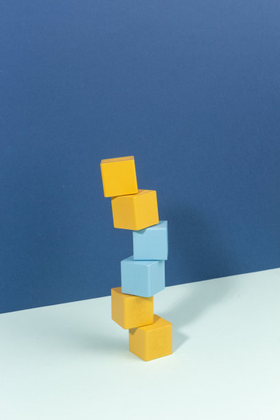 静物概念平衡木制建筑立方体堆积在深蓝色和浅蓝色的背景。俯视图图片下载