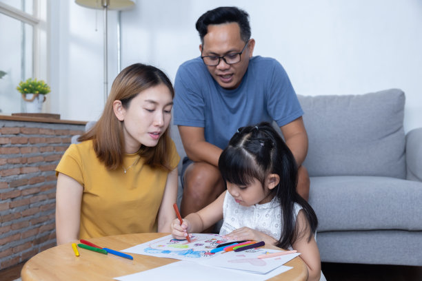 亚洲父母看着女儿在纸上画卡通图片下载
