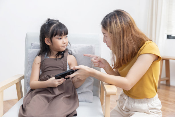 伤心的亚洲母亲抢过孩子的手机阻止女儿沉迷游戏图片下载