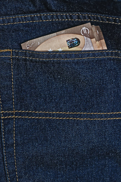 蓝色牛仔裤后口袋里的钞票。省钱的概念。照片的特写。图片下载