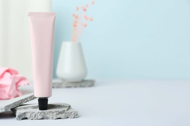 浅灰色的桌子上放着一筒护手霜，给文字留出空间图片下载