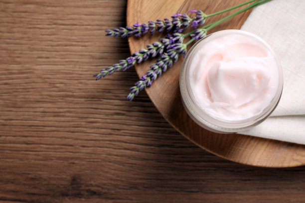 木桌上放着一罐面霜和薰衣草花，俯视图。文本空间图片下载