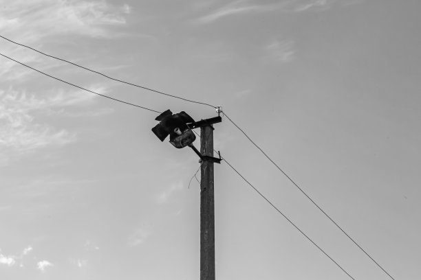 光背景上有电线的动力电线杆近景图片下载