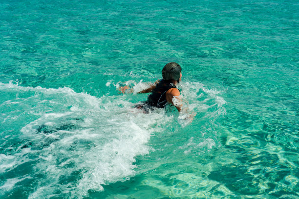 戴着头盔的男子在蓝色的海面上滑翔图片下载