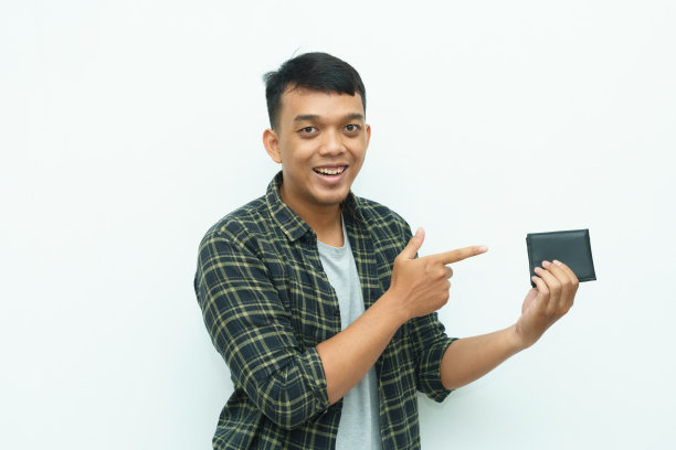 年轻的亚洲男子微笑着指着黑色的钱包图片下载