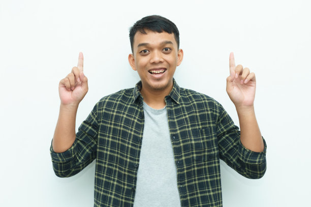 年轻的亚洲男子微笑着用食指指着天空图片下载