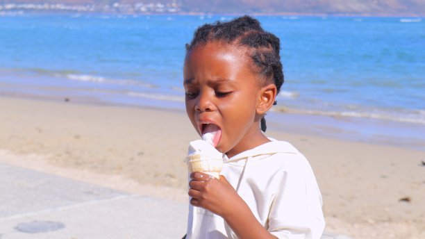 孩子在海滩上吃冰淇淋图片下载
