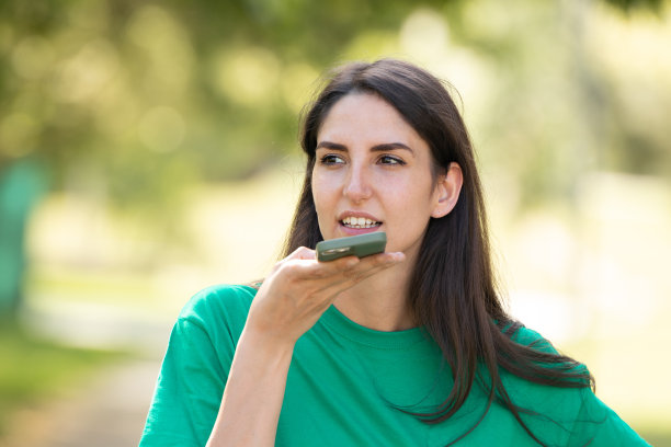 夏天，一个女孩在街上用手机录语音信息图片下载