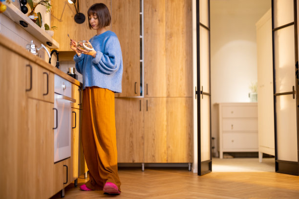 一位女士在时尚的厨房里享用早餐图片下载