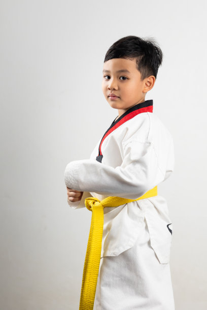 肖像亚洲男孩小孩空手道武术。黄腰带跆拳道服。亚裔男生被孤立在白底横幅上图片下载