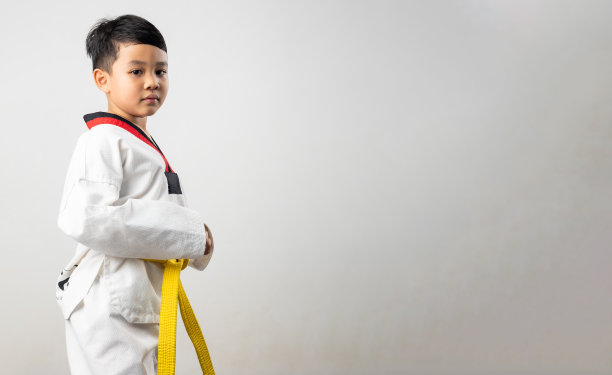 肖像亚洲男孩小孩空手道武术。黄腰带跆拳道服。亚裔男生被孤立在白底横幅上图片下载