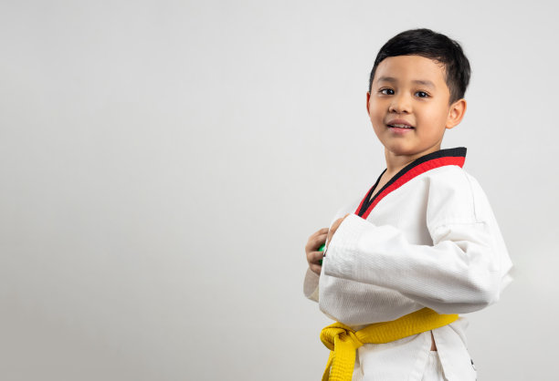 肖像亚洲男孩小孩空手道武术。黄腰带跆拳道服。亚裔男生被孤立在白底横幅上图片下载