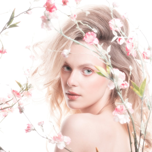 美丽的女人与大波浪的头发和鲜花工作室的肖像图片下载