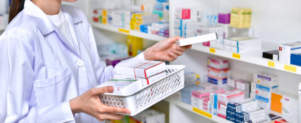 站着的药剂师、药剂师、女药剂师把药房里的新货装满货架图片下载