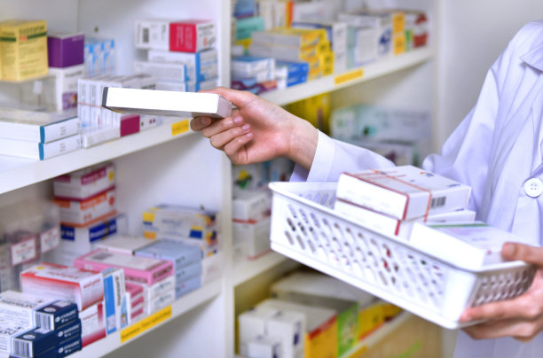 站着的药剂师、药剂师、女药剂师把药房里的新货装满货架图片下载