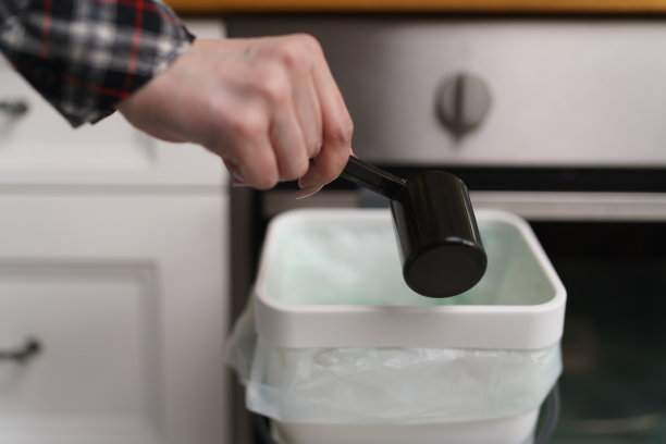 一名妇女用手向堆肥箱中倒入博卡什发酵麸皮。负责任的妇女将有机食物剩余物和废物转化为天然肥料图片下载