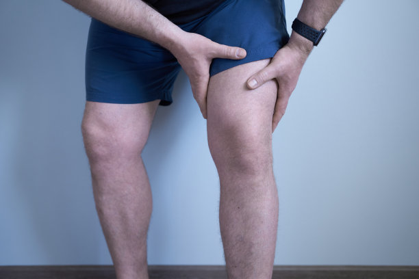 一个男人腿的特写。一个人用手托着他的腿。图片下载