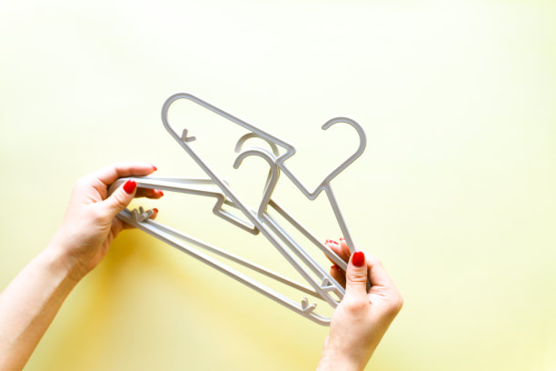 黄色背景上的手握衣架图片下载