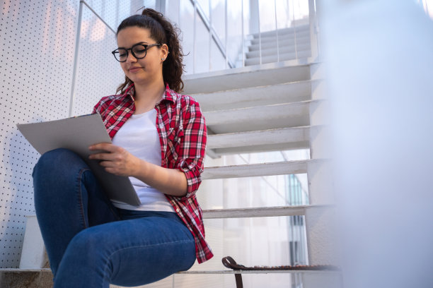 年轻女子正坐在楼梯上画画图片下载