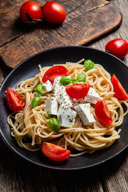 意大利面配羊乳酪和西红柿。意大利面食图片下载
