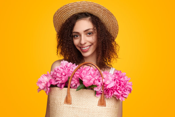 拿着一袋花的快乐的年轻女人图片下载