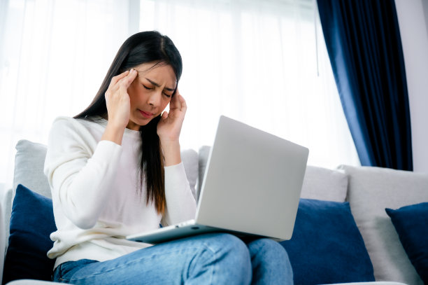 办公室综合症。劳累过度的年轻亚洲女性在电脑工作后感到头痛和视力问题。紧张的年轻女子在家里饱受疲劳之苦图片下载