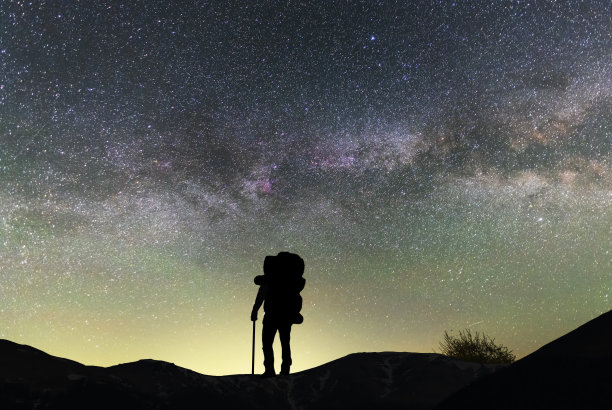 梦幻的风景，一个徒步者站在山上的剪影，在银河系的背景。图片下载