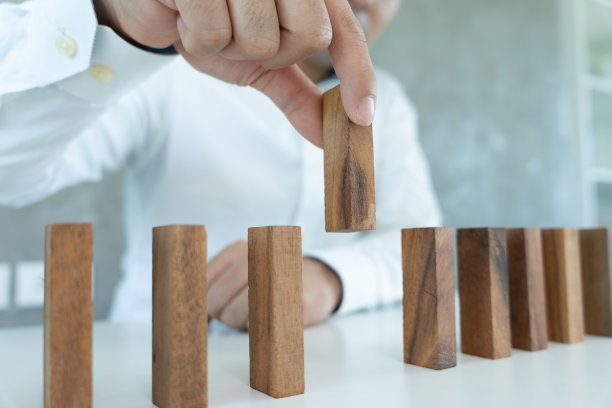 保险用手保护多米诺骨牌。手停止多米诺骨牌倒塌危机。对企业经营风险进行控制，并制定经营防范计划和策略。押金，医疗费，房租，家庭护理费。图片下载