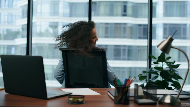 兴奋的女商人坐在现代办公室近距离阅读笔记本电脑上的好消息图片下载