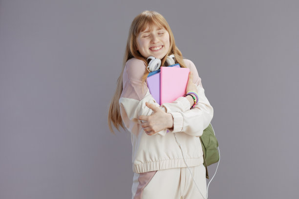 快乐的时尚学生穿着米色运动服拥抱自己图片下载